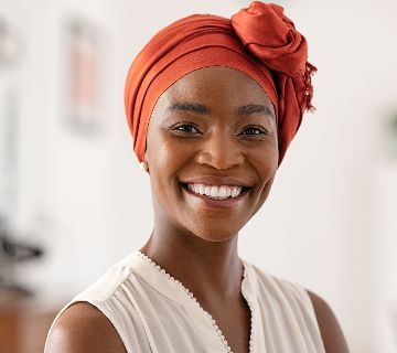 Smiling woman wearing a red headscarf.