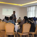 Man presenting to a group in a classroom.