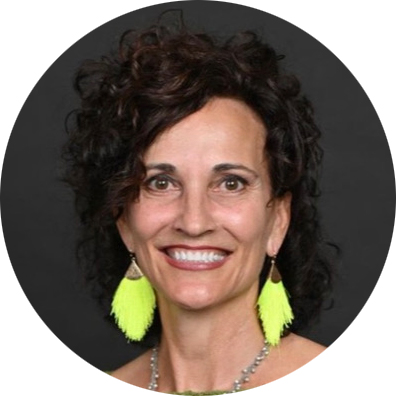 Smiling woman with curly hair and earrings.