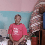 Woman sitting on a bed indoors.