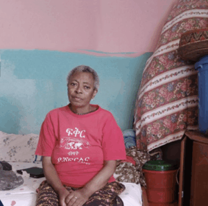 Woman sitting on a bed indoors.