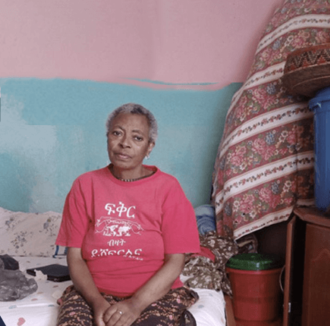 Woman sitting on a bed indoors.